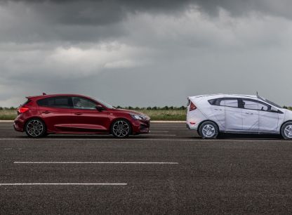 A red car and a white AB Dynamics dummy car on a testing track